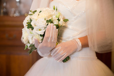 Midsection of bride holding bouquet during wedding
