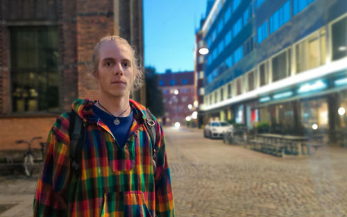 Portrait of man standing against city