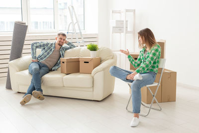 Couple sitting at home with cardboard boxes