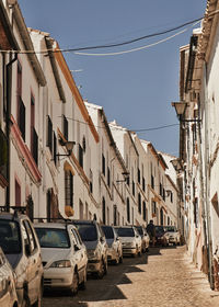 Cars on street amidst buildings against clear sky