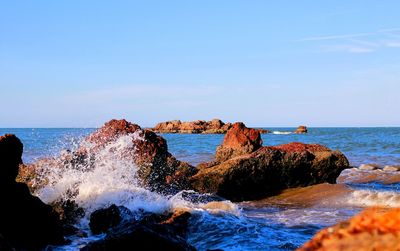 Scenic view of rocks in sea against sky