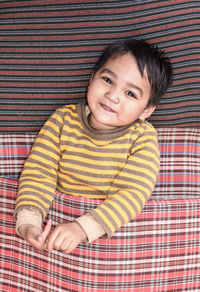 Portrait of smiling boy sleeping on bed