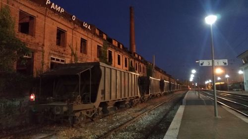 Train on railroad tracks against sky at night