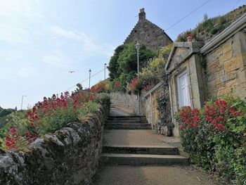 Footpath by building against sky