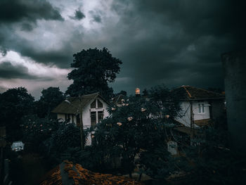 Low angle view of trees and buildings against sky