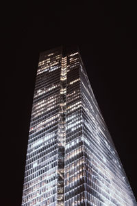 Low angle view of illuminated buildings against sky at night