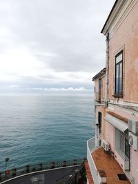 Buildings by sea against sky