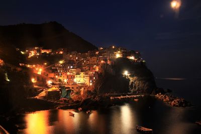 Illuminated cityscape against sky at night