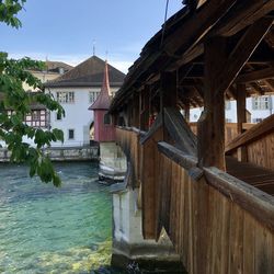 Buildings by river against sky