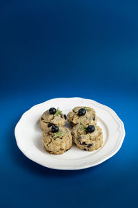 High angle view of cookies in plate against blue background