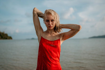 Portrait of young woman standing at beach