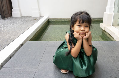 Portrait of cute girl sitting outdoors