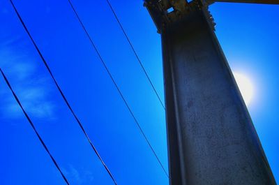 Low angle view of cables against clear blue sky