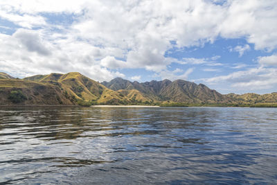 Scenic view of lake by mountains against sky