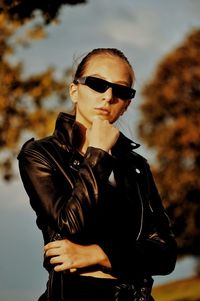 Young man wearing sunglasses standing against sky