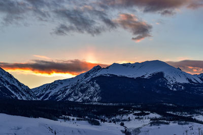 Scenic view of snowcapped mountains against sky during sunset