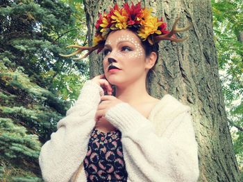 Portrait of beautiful young woman with tree