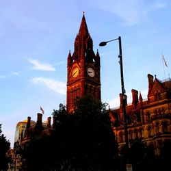 Low angle view of clock tower amidst buildings in city