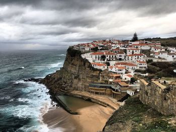 Scenic view of sea by cliff against sky