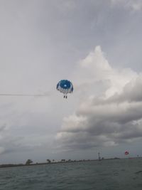People paragliding over sea against sky
