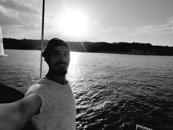 Portrait of man in boat on lake against sky