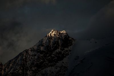 Low angle view of snow covered mountain against sky