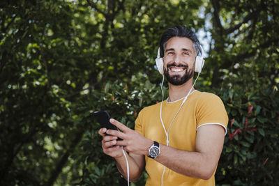 Portrait of smiling young man using mobile phone