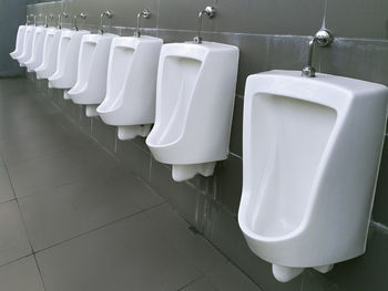 Close up row of urinal toilet blocks in public restroom