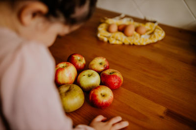 Midsection of woman holding fruits on table