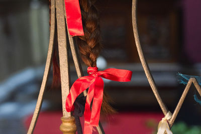 Close-up of red ribbon tied on brown hair