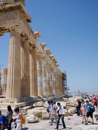 Tourists against clear blue sky