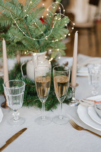 Christmas decor of the festive table, two glasses of champagne, serving dinner for a couple in love