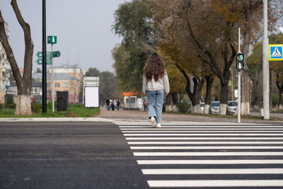 Rear view of girl crossing road