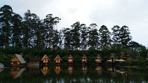 Dusun bambu restaurant by lake against trees