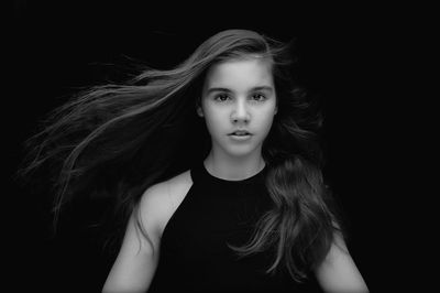Portrait of girl with long hair against black background
