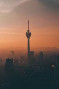 Silhouette of buildings in city during sunset