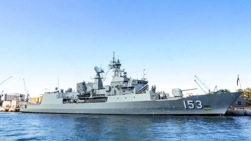 Ship moored at harbor against clear blue sky