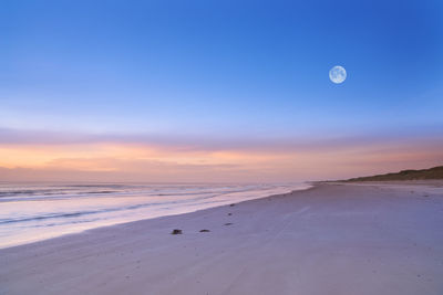 Scenic view of beach against sky during sunset