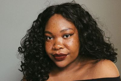 Close-up portrait of woman against gray background