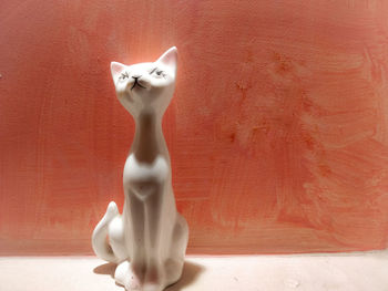 Close-up of white cat sculpture against wall