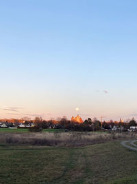 Scenic view of field against clear sky during sunset