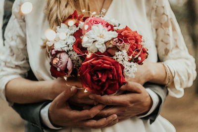 Midsection of woman holding rose bouquet