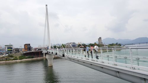 People sailing on river against sky