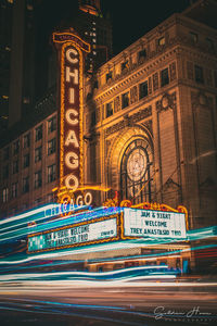 Light trails on street against building at night