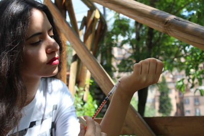 Close-up of young woman by tree