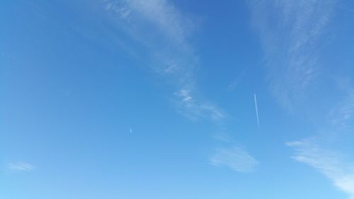 Low angle view of vapor trail in blue sky