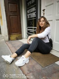 Portrait of woman sitting on tiled floor