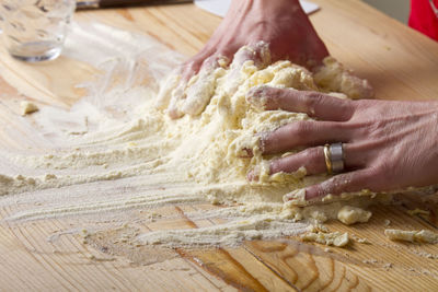 Cropped image of hand kneading pasta dough in kitchen