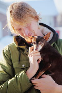 Young man eating dog