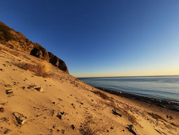 Scenic view of beach against clear blue sky